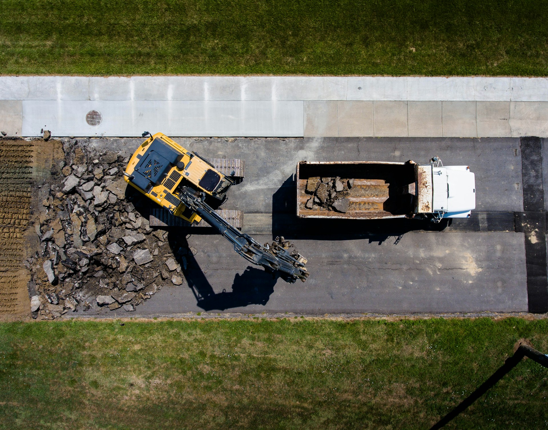 Aerial view of an excavator loading material into a truck