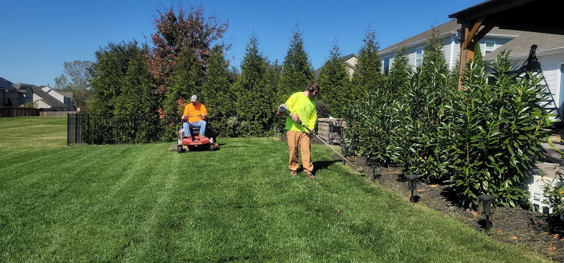 Landscaping crew maintaining a finished residential yard